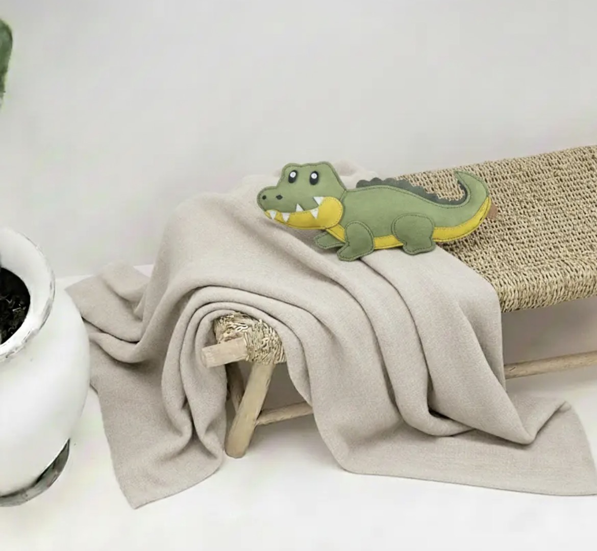 Jouet Grand Crocodile en cuir Bibizy, posé sur un plaid